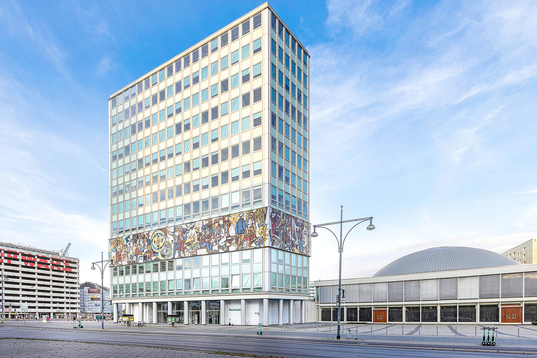 Das Haus des Lehrers in der Bildmitte vor blauem Himmel.