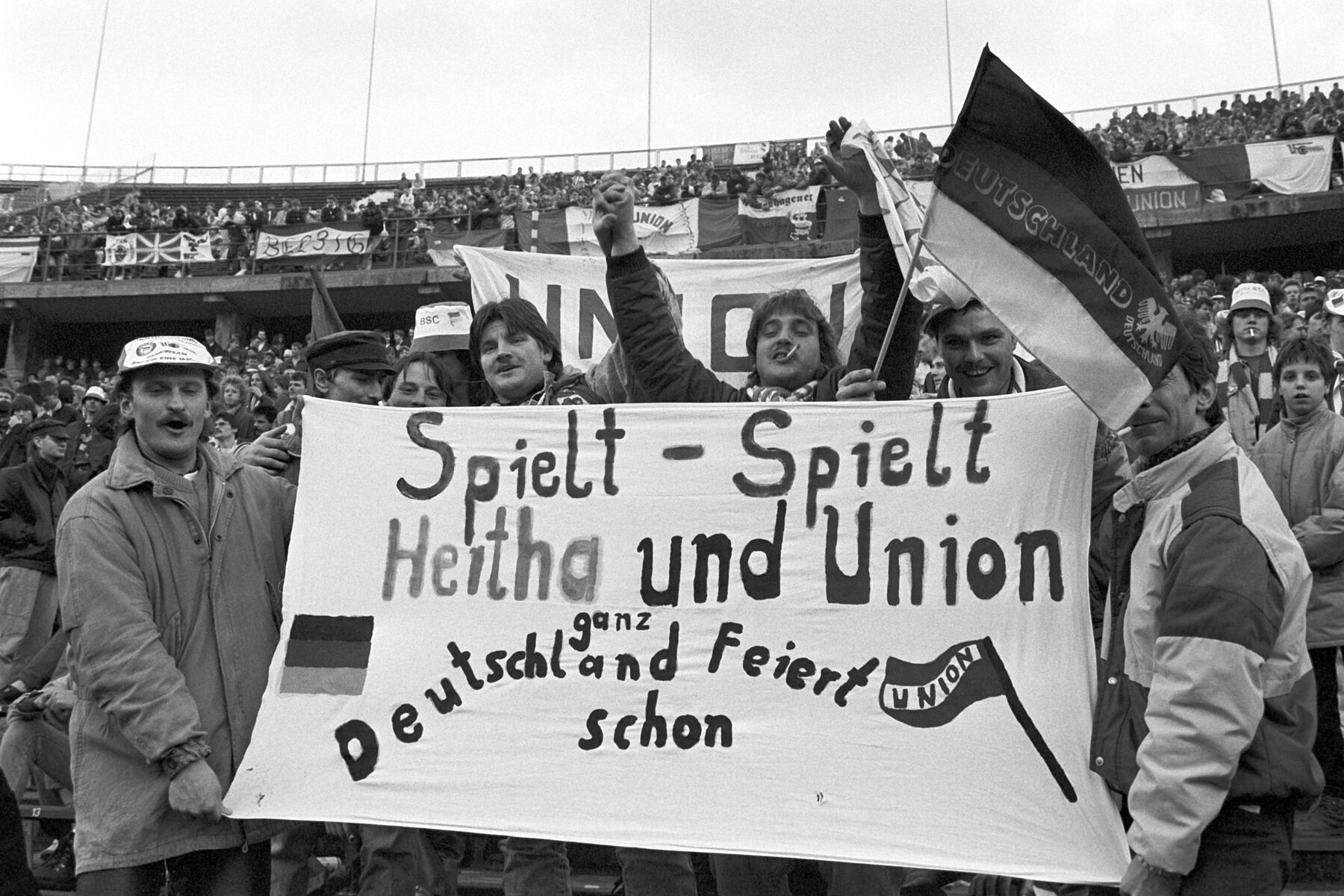 Fans halten eine Transparat mit dem Schriftzug: Spielt – spielt, Hertha und Union, ganz Deutschland feiert schon.