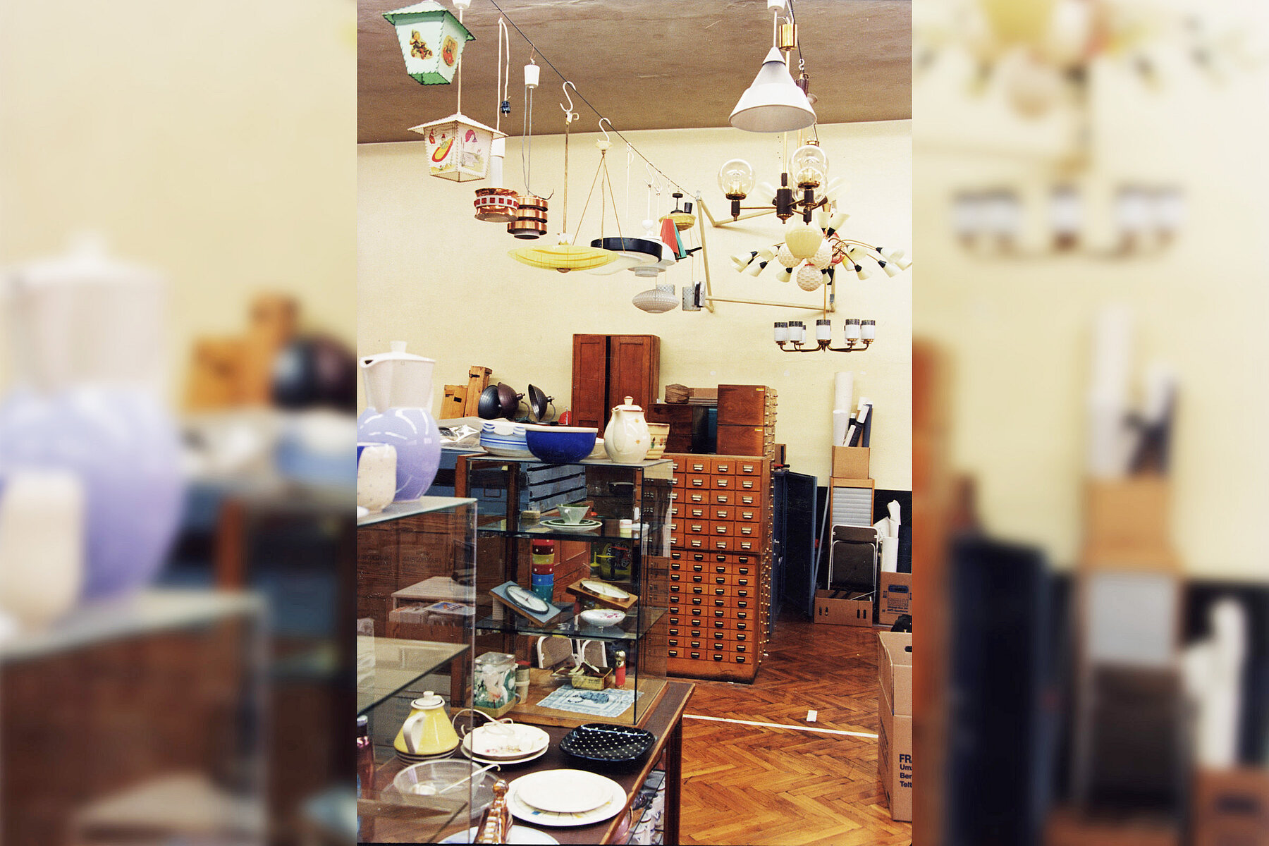 Zeitweiliges Depot der Sammlung industrielle Gestaltung. Diverse Objekte der Designsammlung, wie Lampen, Teller und Schränke befinden sich in einem Raum.