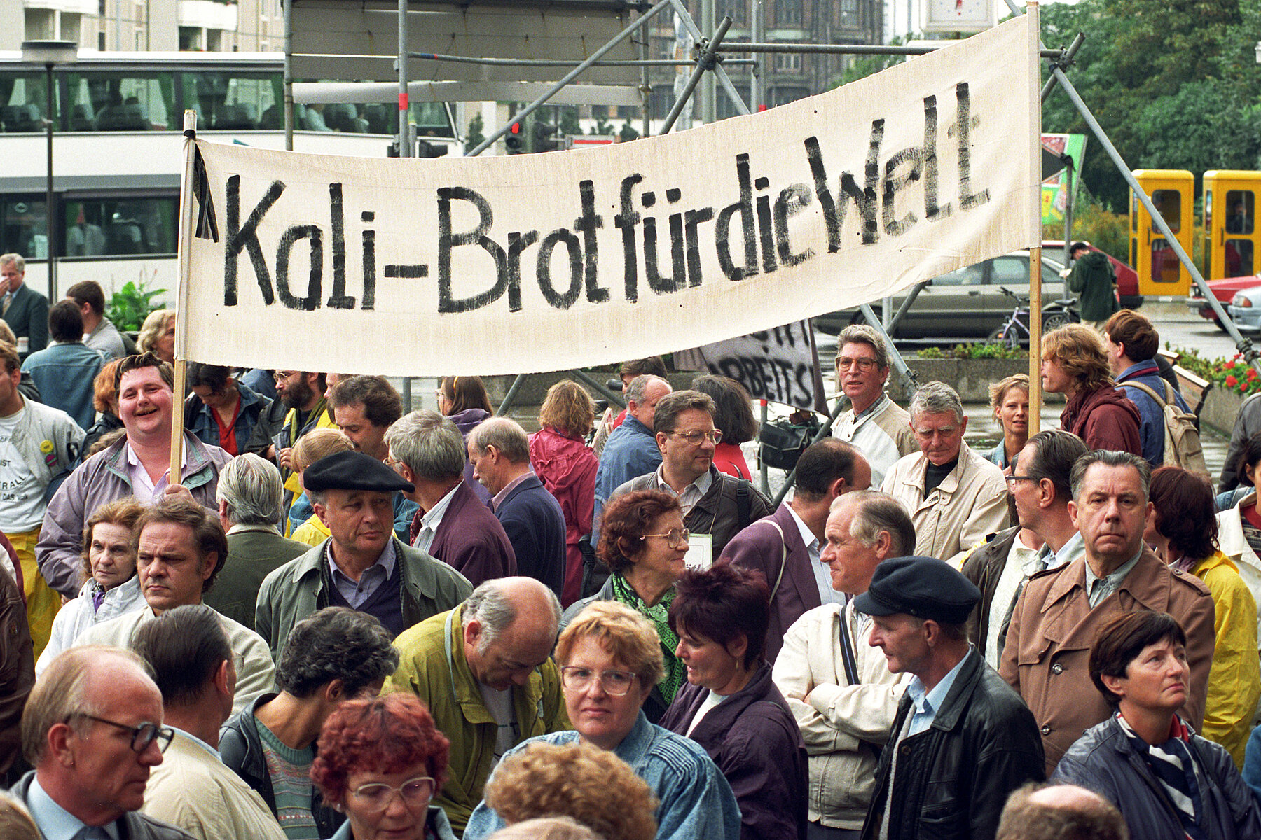 Demonstrierende mit einem Transparent, auf dem der Schriftzug steht: Kali-Brötchen für die Welt.
