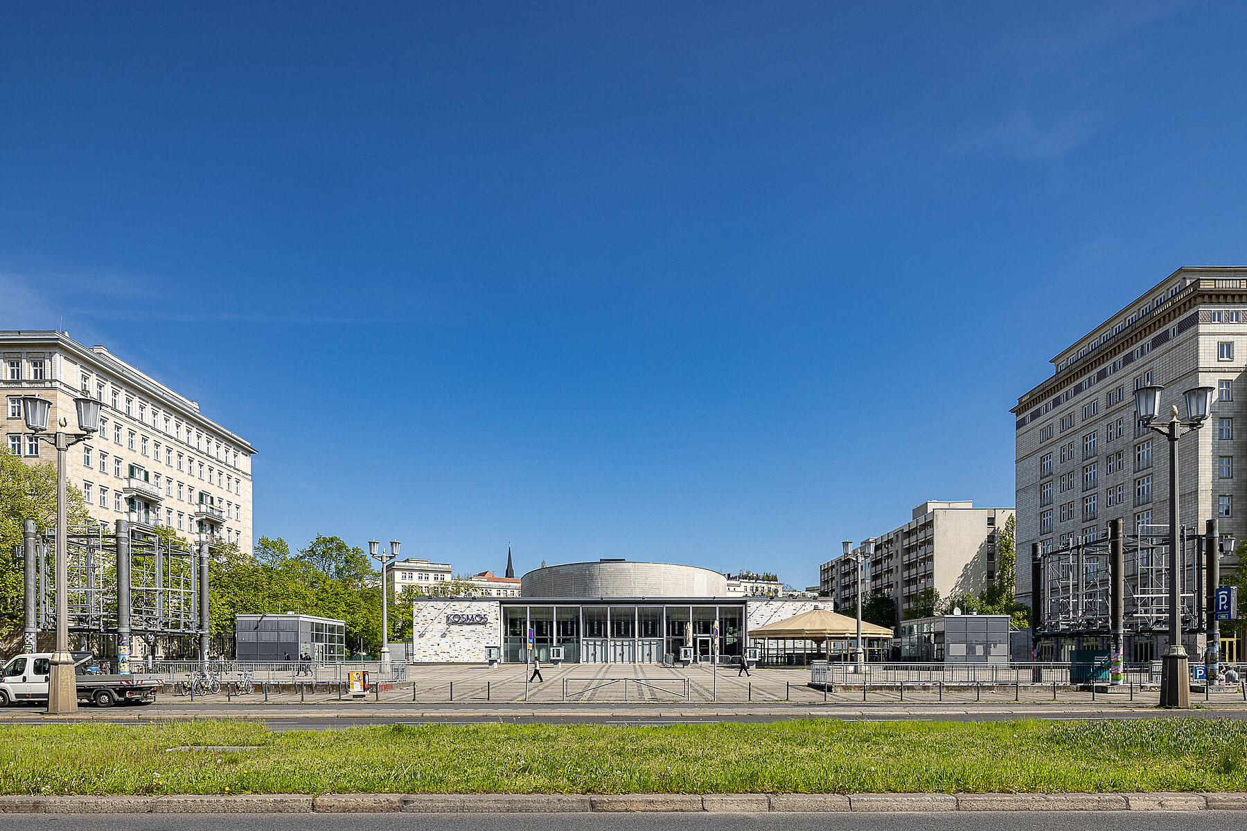 Das Kosmos-Gebäude von der Straße aus, eingerahmt zwischen Wohnhäusern.