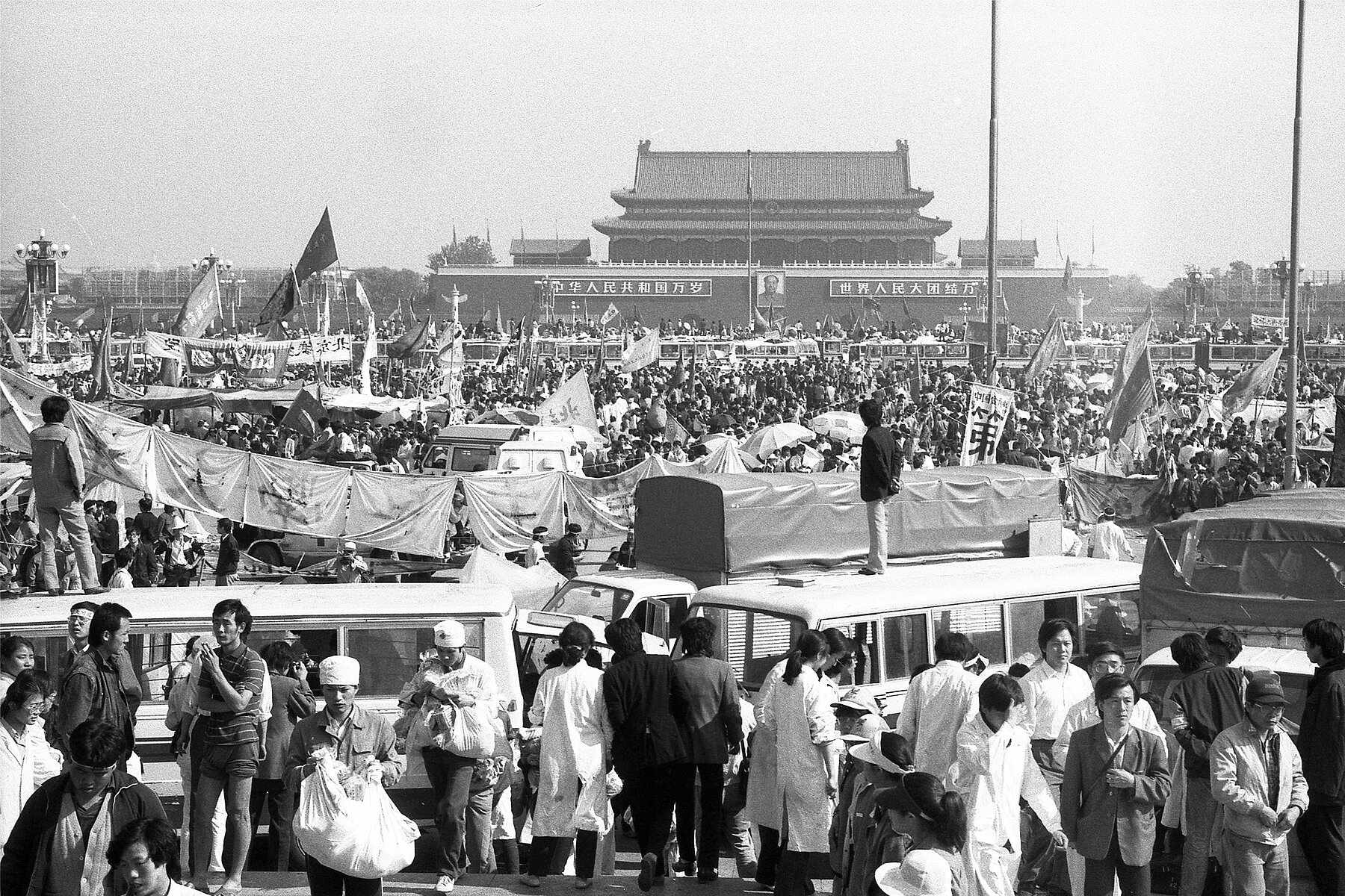 Eine große Masse Studierender auf dem Platz des Himmlischen Friedens in Peking, im Hintergrund befindet sich die Verbotene Stadt.
