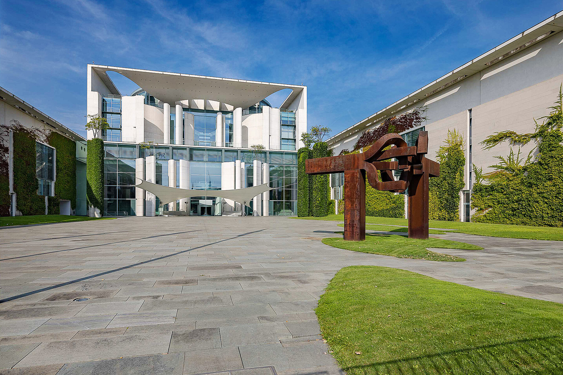 The entrance area of the Federal Chancellery, with a sculpture in the foreground on the right.