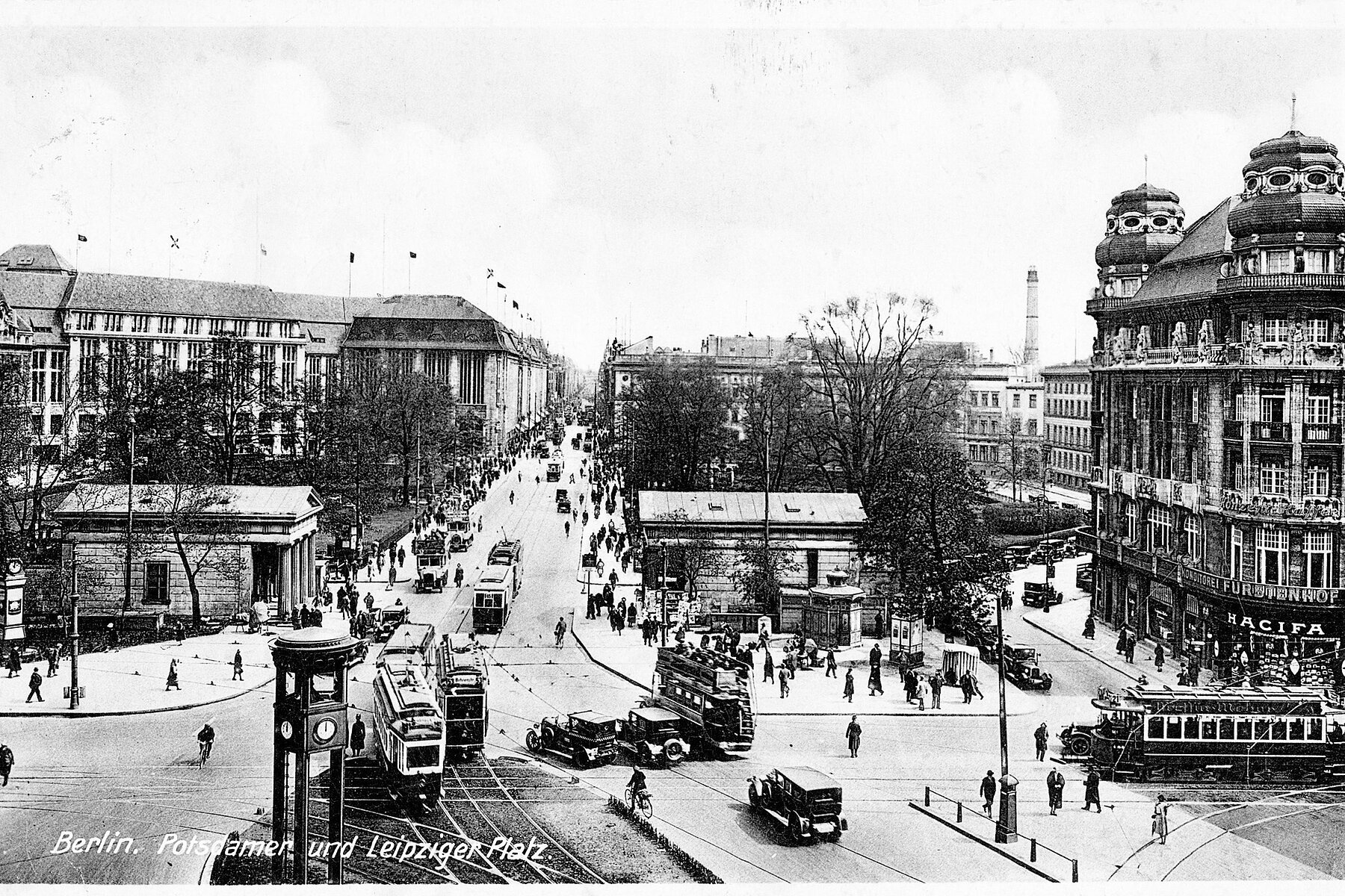 Historical postcard of a street scene at Potsdamer Platz with traffic lights, tram traffic and cars in the foreground, surrounding various buildings.