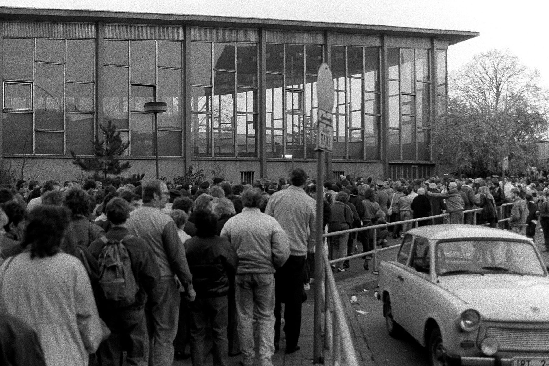 Crowds of people in front of the Tränenpalast, on the right is a Trabi.