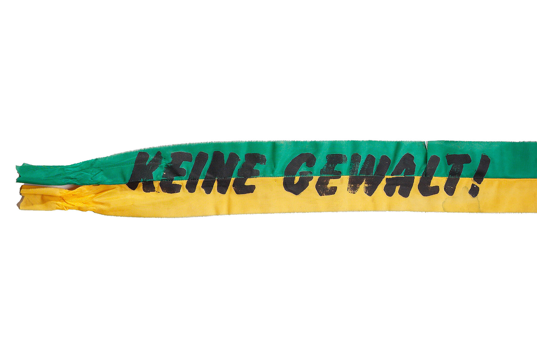 A green and yellow sash with the slogan No Violence in black letters.