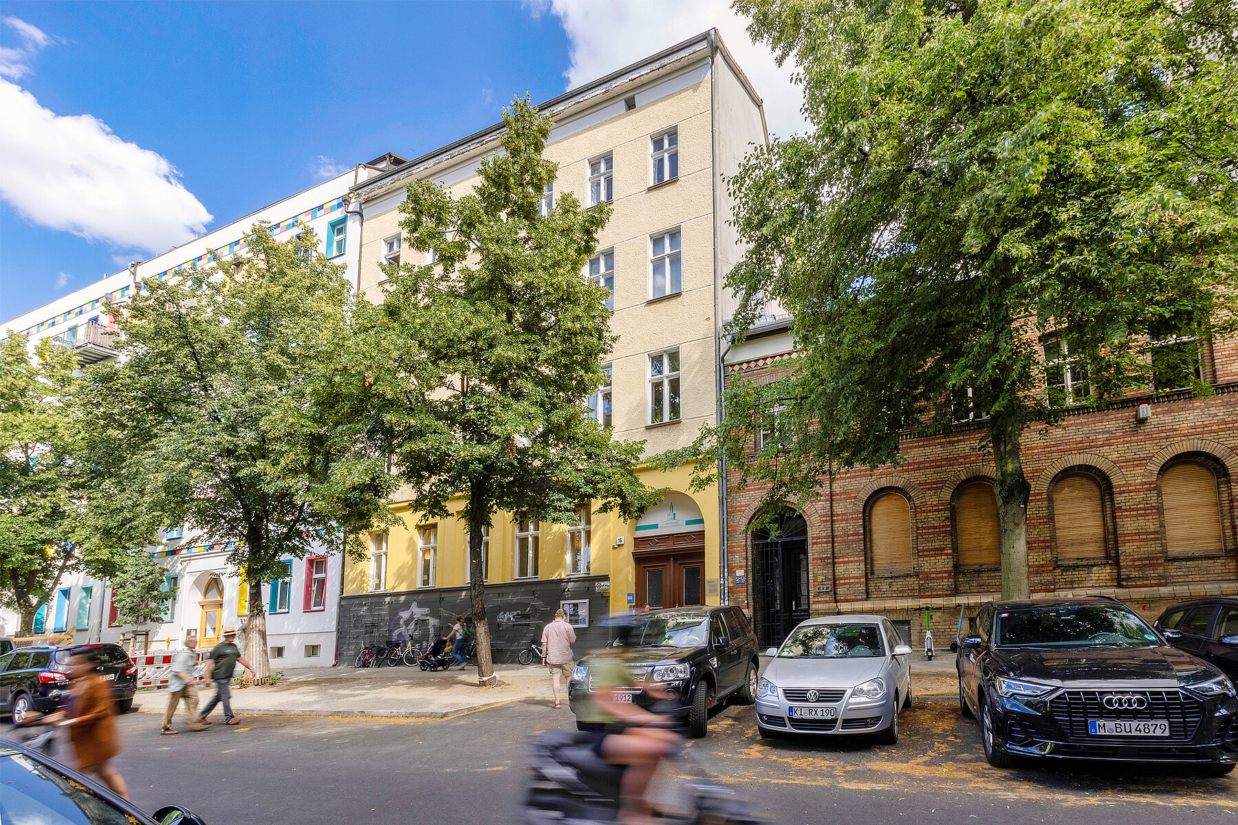 The yellow painted community centre of the Zionskirche surrounded by apartment houses.