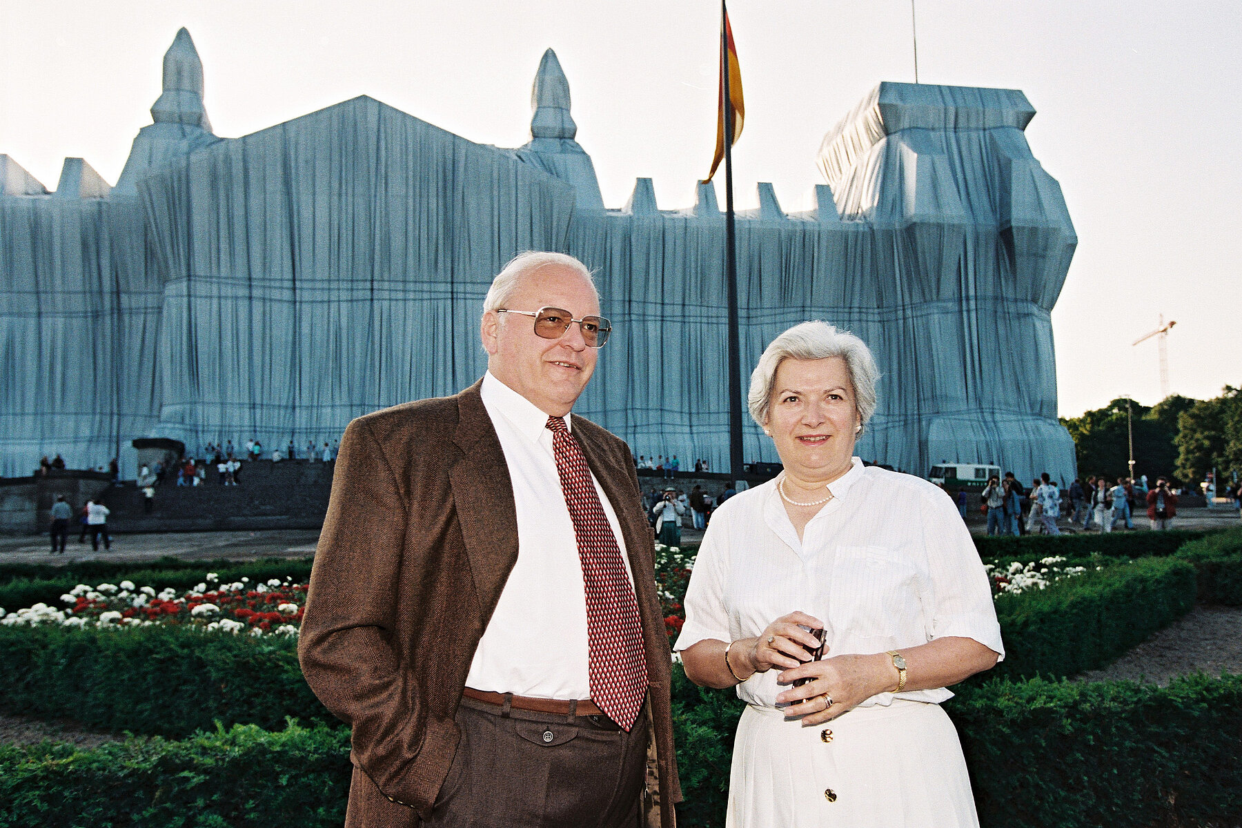 Roman and Christiane Herzog stand in front of Reichstag building which is covered in white.