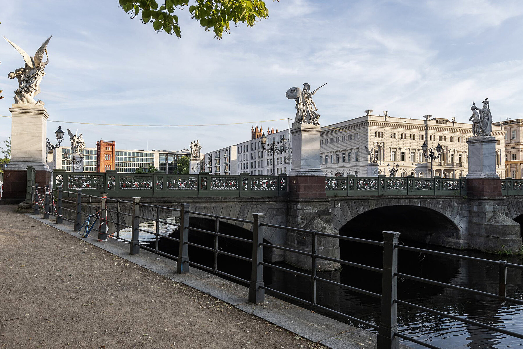 Die Schlossbrücke über der Spree mit Skulpturen von Kriegern und Siegesgöttinnen auf Sockeln. Im Hintergrund das Kommandantenhaus.