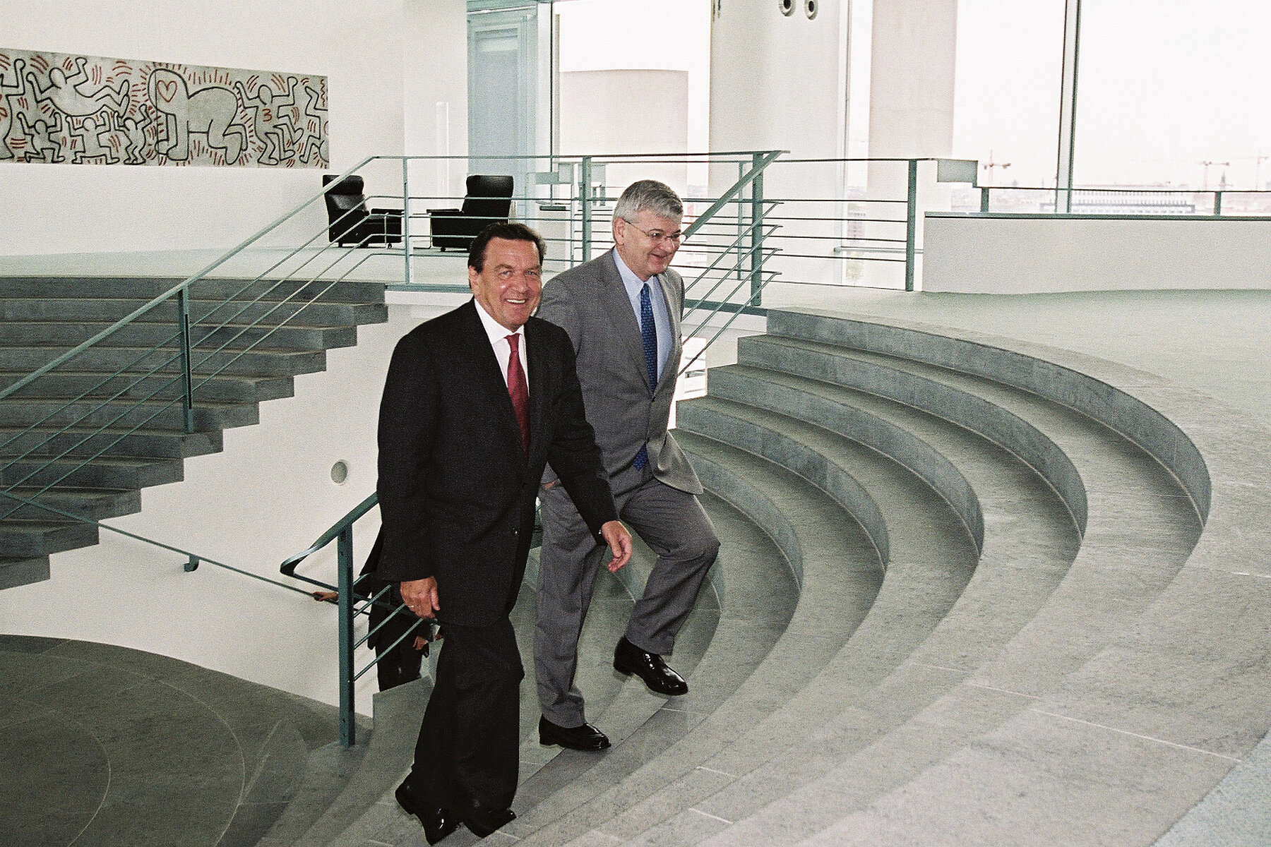 Gerhard Schröder und Joschka Fischer steigen eine Treppe im Bundeskanzleramt herauf.