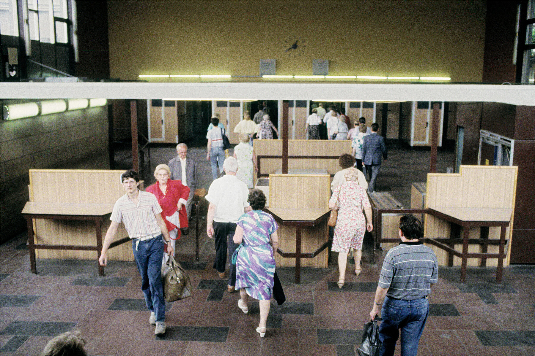 People pass through the border control checkpoint in the entrance hall.