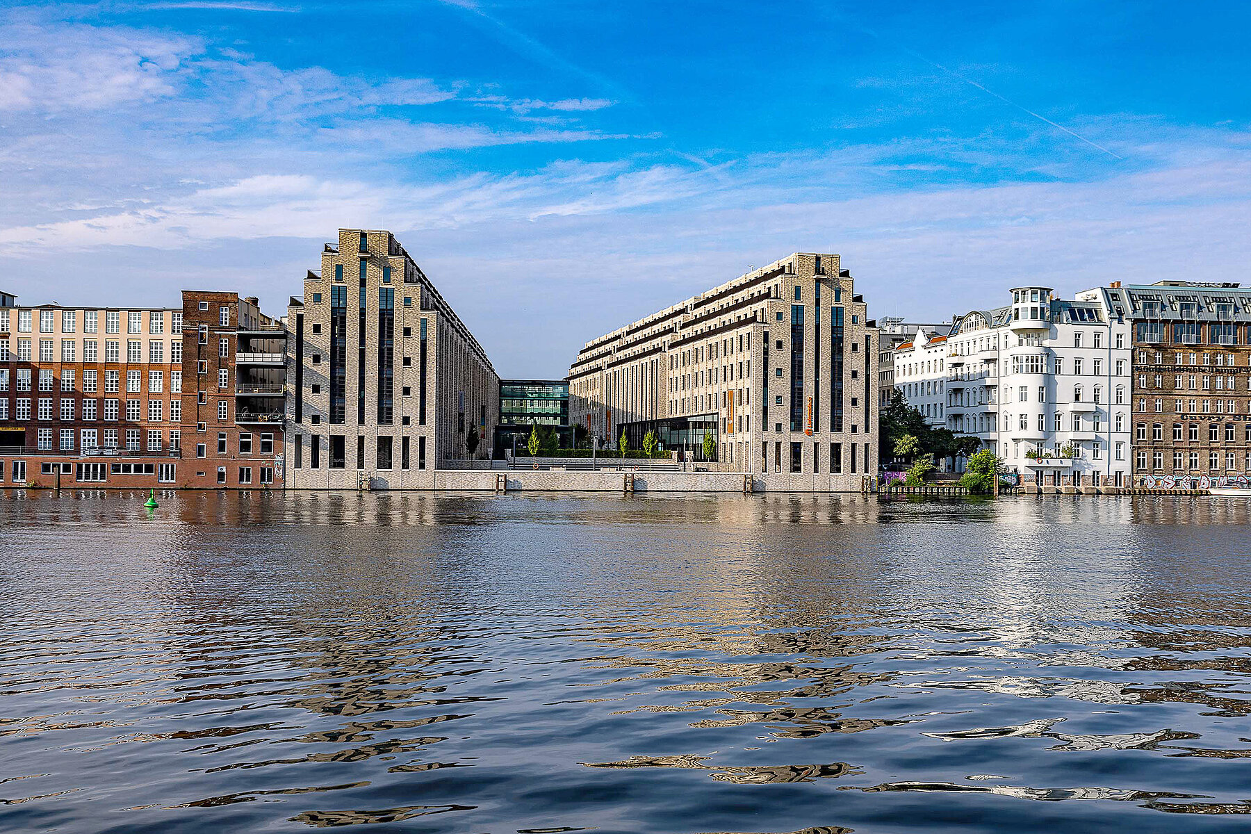 Neu gebaute Hochhäuser mit treppenförmigen Dächern an der Spree.