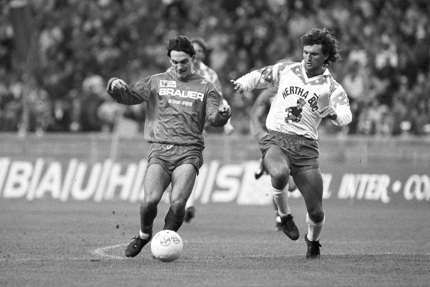 A Hertha player and a Union player in a duel for the ball.