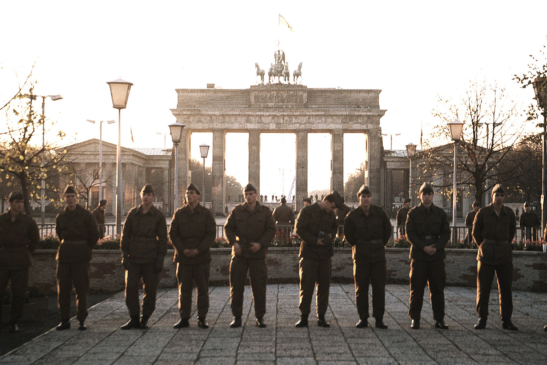 Grenzsoldaten stehen nebeneinander in einer Reihe und blockieren das Brandenburger Tor.