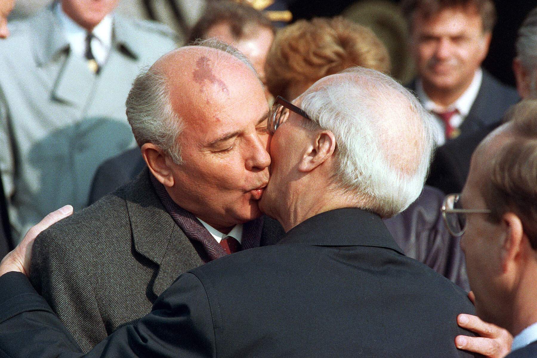 Mikhail Gorbachev hugs Erich Honecker and kisses him on the cheek.