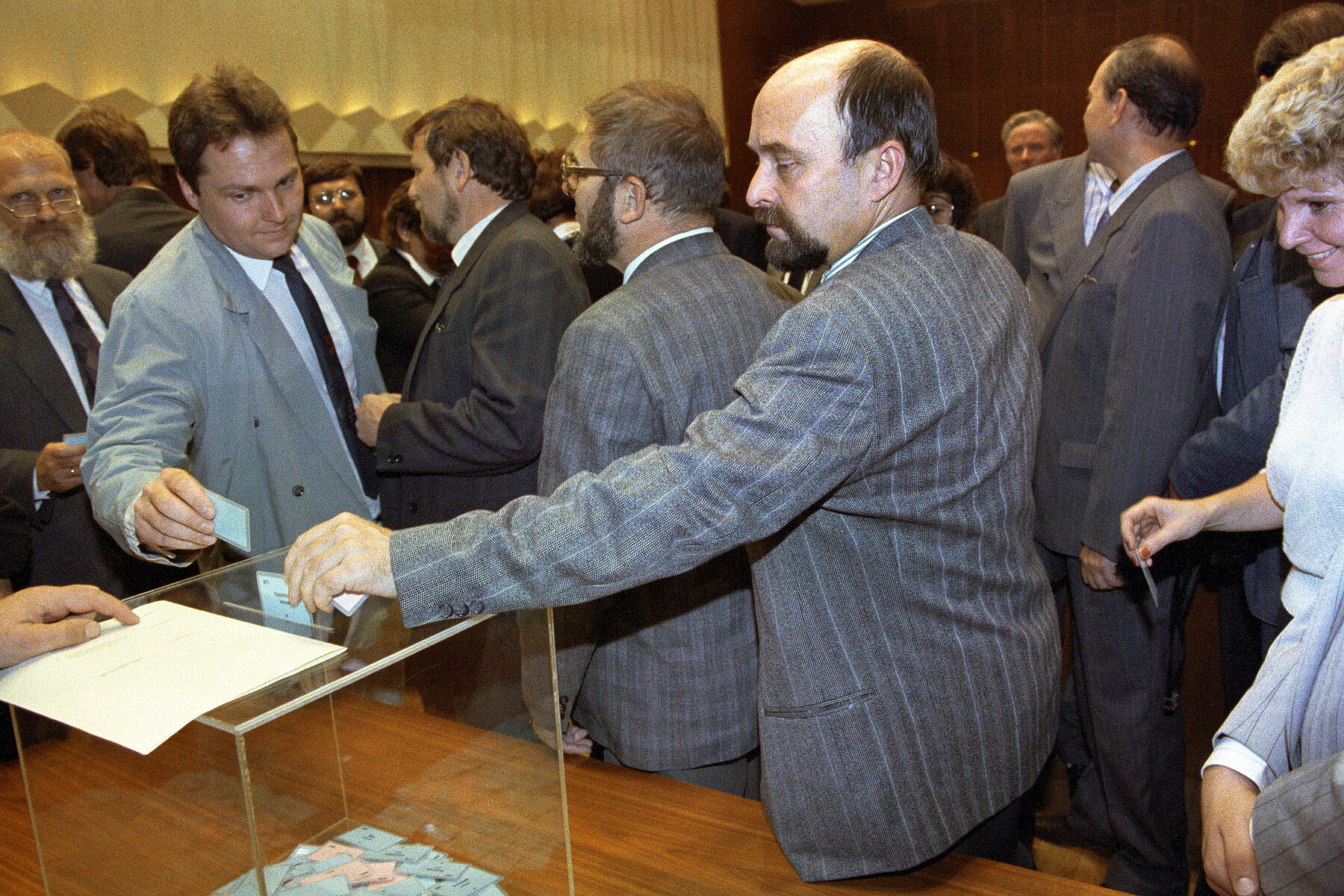 GDR Minister for Disarmament and Defense Rainer Eppelmann drops his ballot into a transparent ballot box.